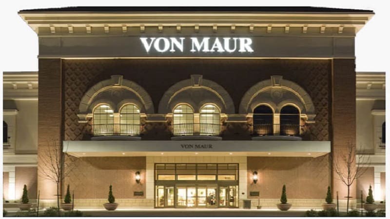 An unidentified person prays outside the Von Maur department store